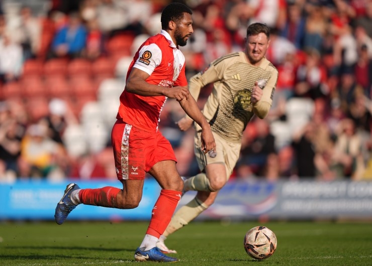 Kidderminster Harriers' Reiss McNally sprints away from his opponent during a football match.