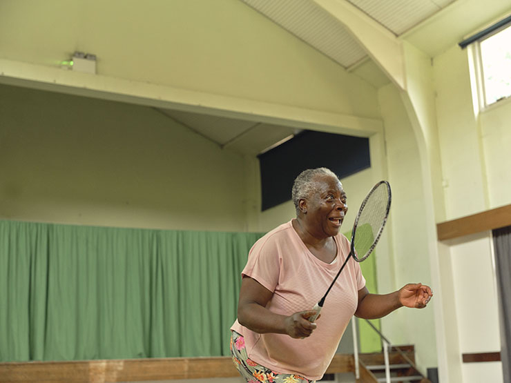 A woman plays badminton in a hall