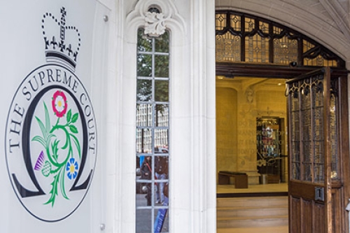 A general view of the UK Supreme Court, with the logo on the left side of the door, and the door open, looking in