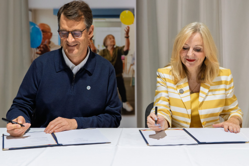 Sport England chief executive Simon Hayes and West Yorkshire mayor Tracy Brabin sign a memorandum of understanding at a table.