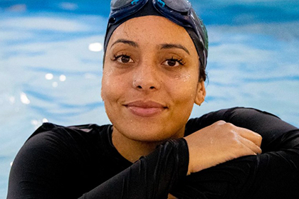 Headshot of Omie Dale wearing a swimming cap in a pool.