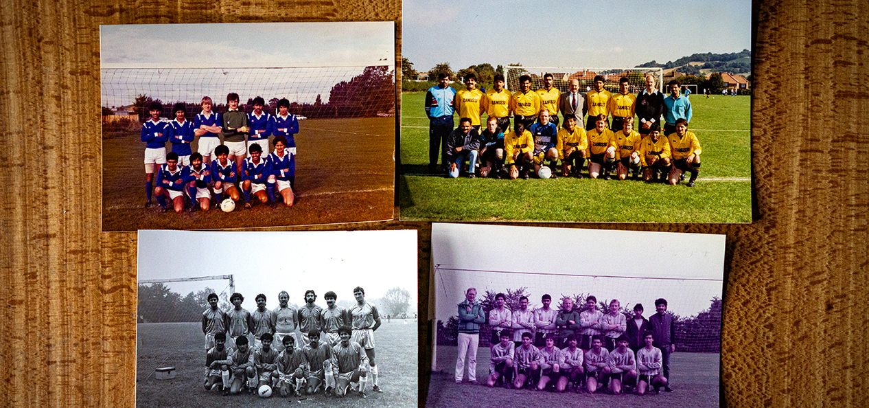 Four photographs of Rising Starts FC'74 teams through the years are placed on a table.