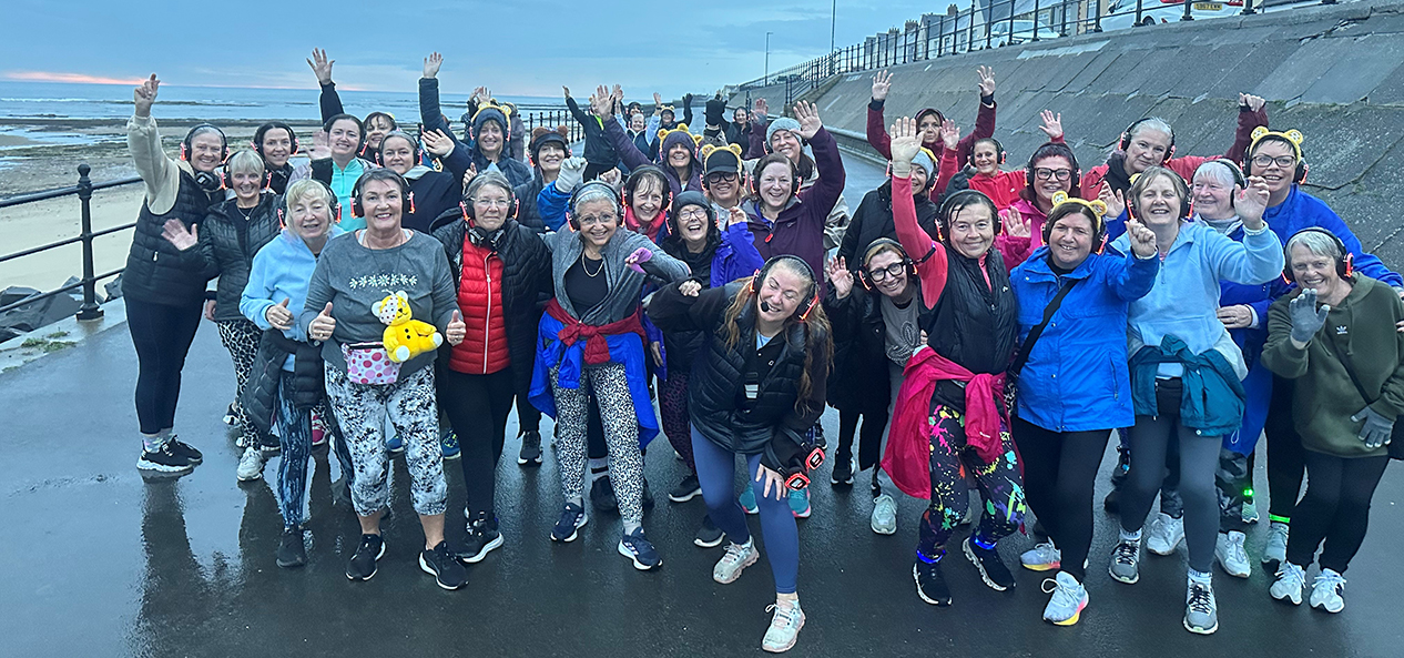 A group of Silent Steppers pose by the sea after one of their exercise sessions. 