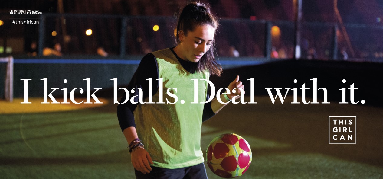A woman juggles a football on an outdoor artificial pitch, with overlaid text reading 'I kick balls - deal with it', and the logos of This Girl Can, Sport England and The National Lottery on the sides.
