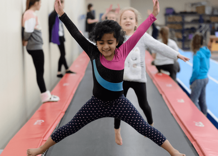 Young girls jumping on long trampoline.
